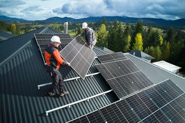 Technicians from AP Sun Energy installing solar panels on a residential rooftop under a bright blue sky, demonstrating professional renewable energy solutions