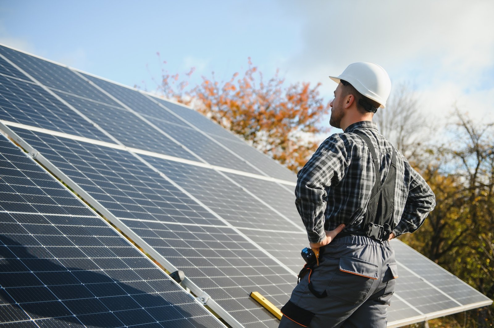 Professional worker installing solar panels on the metal construction