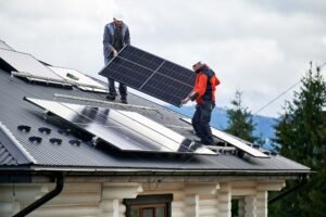 Technicians installing solar panels on roof of house